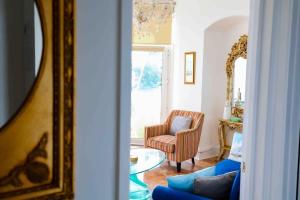 a living room with a blue couch and a chair at Luxury Riviera View Waterside Apartment in Torquay