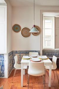 ein Esszimmer mit einem weißen Tisch und Stühlen in der Unterkunft Inglesinhos Convento 1 - Charming Apartment in Lissabon