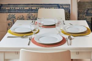 einem weißen Tisch mit Tellern und Gläsern darauf in der Unterkunft Inglesinhos Convento 1 - Charming Apartment in Lissabon