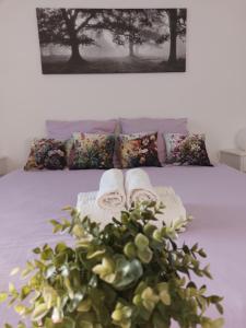 ein Bett mit zwei Handtüchern und einer Pflanze darauf in der Unterkunft Villa Bianca - Holiday & Business in Elsenfeld