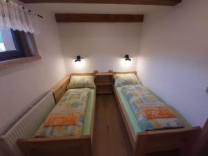 two beds in a small room with two lights at Penzion Na Kamyncu in Jablunkov