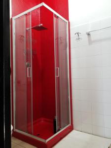 a shower in a bathroom with a red wall at Casa Nunzia in Domodossola