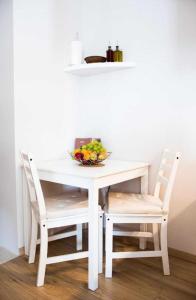 un tavolo bianco con due sedie e un cesto di frutta di Studio A a Dubrovnik