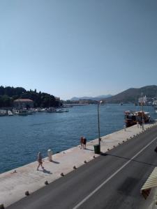 un gruppo di persone che camminano su un marciapiede vicino all'acqua di Studio A a Dubrovnik