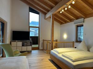 een slaapkamer met een bed en een flatscreen-tv bij Ferienwohnung Richter in Rettenberg