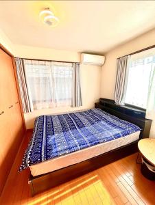 Cama en habitación con 2 ventanas en 吉吉の家, en Tokio