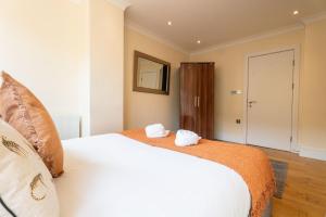 a bedroom with a large white bed and a mirror at Vibrant Old City 2BR Apartment - Full Kitchen WiFi in Bristol