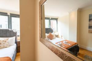 a mirror in a bedroom with a bed and a couch at Vibrant Old City 2BR Apartment - Full Kitchen WiFi in Bristol