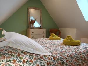 een slaapkamer met een bed met een spiegel erop bij Ancienne maison de pêcheurs in Saint-Marcouf