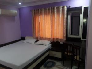 ein kleines Schlafzimmer mit 2 Betten und einem Fenster in der Unterkunft Hotel President inn Raxaul in Raxaul