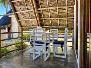 a table and chairs on a porch with a view of the ocean at Surya Beach Resort Palawan in Aborlan