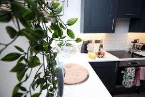 a kitchen with a wooden cutting board on a counter at Chic 3-Bed Stay Near Cardiff’s Top Sights in Cardiff