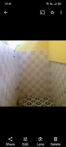 uma casa de banho com um chuveiro e piso em azulejo em The Hideout em Kampot