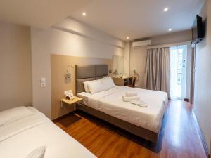 Un pat sau paturi într-o cameră la Anemoni Piraeus Hotel