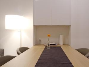 een lange tafel in een kamer met een vaas met een bloem bij Balcony Dream Mariahilf Top 29 in Wenen