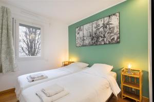 2 weiße Betten in einem Zimmer mit Fenster in der Unterkunft T3 - PARIS 10' Confort & Modern - Terrasse - Parking - WIFI in Gentilly