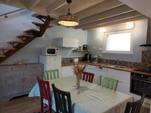 a kitchen with a table and chairs and a kitchen with a staircase at Ancienne maison de pêcheurs in Saint-Marcouf
