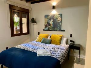 a bedroom with a blue bed with yellow pillows at El Patio de Toledo in Toledo