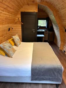 a bedroom with a large bed in a wooden cabin at Domaine de la Butte Ronde in La Boissière-École