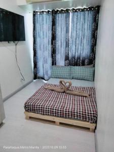 un piccolo letto in una camera con finestra di Azure City 2 bedrooms affordable price a Manila