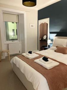 a bedroom with two beds with towels on them at Waverley Apartments, The Wheelhouse in Gourock