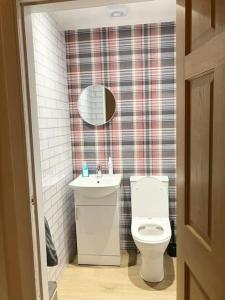 a bathroom with a toilet and a sink and a mirror at The Wheelhouse, Gourock in Gourock