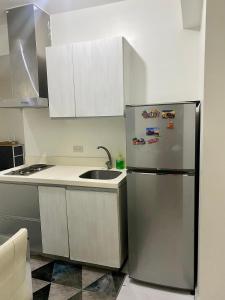 a kitchen with a stainless steel refrigerator and a sink at Azure City 2 bedrooms affordable price in Manila