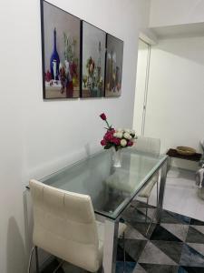 un tavolo di vetro con sedie e un vaso con fiori sopra di Azure City 2 bedrooms affordable price a Manila