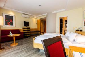 ein Hotelzimmer mit 2 Betten und einem Sofa in der Unterkunft Parkhotel Ropeter in Göttingen