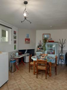 a kitchen and dining room with a table and chairs at une pause quelque part au jardin des érables et des niwakis in Saint-Médard-de-Guizières