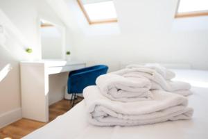 a pile of white towels sitting on top of a bed at Space Apartments - Dovercourt Sea front Duplex Apartment - 1 Bed - Sea Views! in Harwich