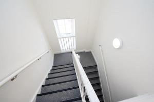 a staircase in a white building with a window at Space Apartments - Dovercourt Sea front Duplex Apartment - 1 Bed - Sea Views! in Harwich