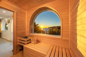 an outside sauna with an arched window and a bench at Luxury Sunset Villa Trogir Private Beach in Okrug Donji