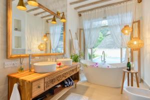 ein Badezimmer mit zwei Waschbecken, einer Badewanne und einem Spiegel in der Unterkunft Zanzi Resort in Zanzibar City