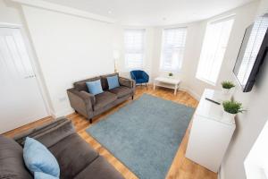 a living room with a couch and a blue rug at Space Apartments - Dovercourt Sea front Duplex Apartment - 1 Bed - Sea Views! in Harwich