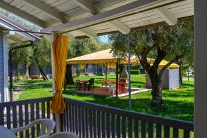 un porche con cenador con mesa y sillas en Villaggio Cilento Azzurro, en Villammare