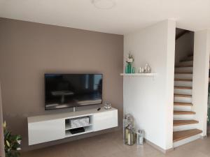 a living room with a flat screen tv on a wall at Fewo Thaler in Burhave