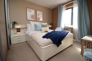 a bedroom with a large bed and a window at Observatory 2 bedroom apartment overlooking Beach in Swansea