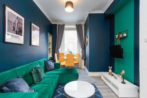 a living room with a green couch and blue walls at Boutique and Beautiful Edinburgh Abode in Edinburgh