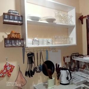 - une cuisine avec une étagère, de la vaisselle et des ustensiles dans l'établissement Gever’s paradise, à Watamu