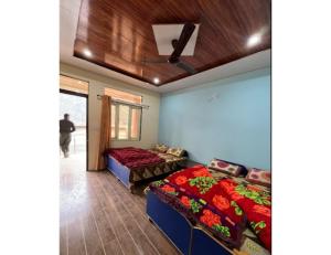 een slaapkamer met 2 bedden en een plafond bij Hotel Vijaya, Dhar Gaon, Phata in Phata