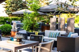 an outdoor patio with tables and chairs and umbrellas at Parkhotel Ropeter in Göttingen