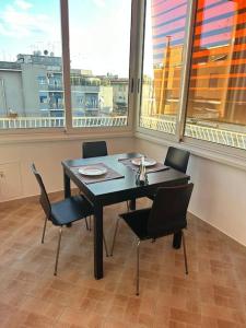 einen Tisch und Stühle in einem Zimmer mit Fenstern in der Unterkunft [Centocelle, Metro C] Luminoso quadrilocale in Rom