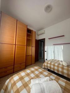 a bedroom with two beds and wooden cabinets at [Centocelle, Metro C] Luminoso quadrilocale in Rome