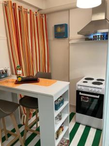 a kitchen with a white counter and a stove at Retro living apartment in Larisa