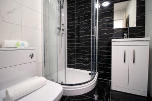 y baño con ducha, aseo y lavamanos. en Smart TV | WiFi | Attractions, en Cardiff