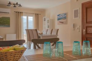 a dining room with a table with blue glasses on it at Dina Apartments Argostoli in Argostoli