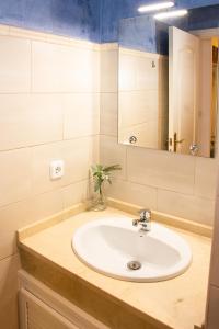 bagno con lavandino e specchio di Apartamento Torre de la Plata a Siviglia