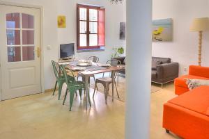 una sala da pranzo e un soggiorno con tavolo e sedie. di Apartamento Torre de la Plata a Siviglia