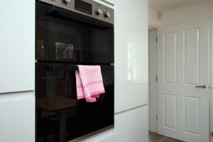 una cucina con forno nero e asciugamano rosso e bianco di 4BR modern house Free Parking Cohost Partners a Newport